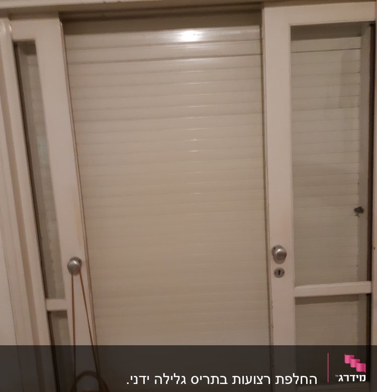 תריסים סגורים על דלת זכוכית עם ידיות מתכת